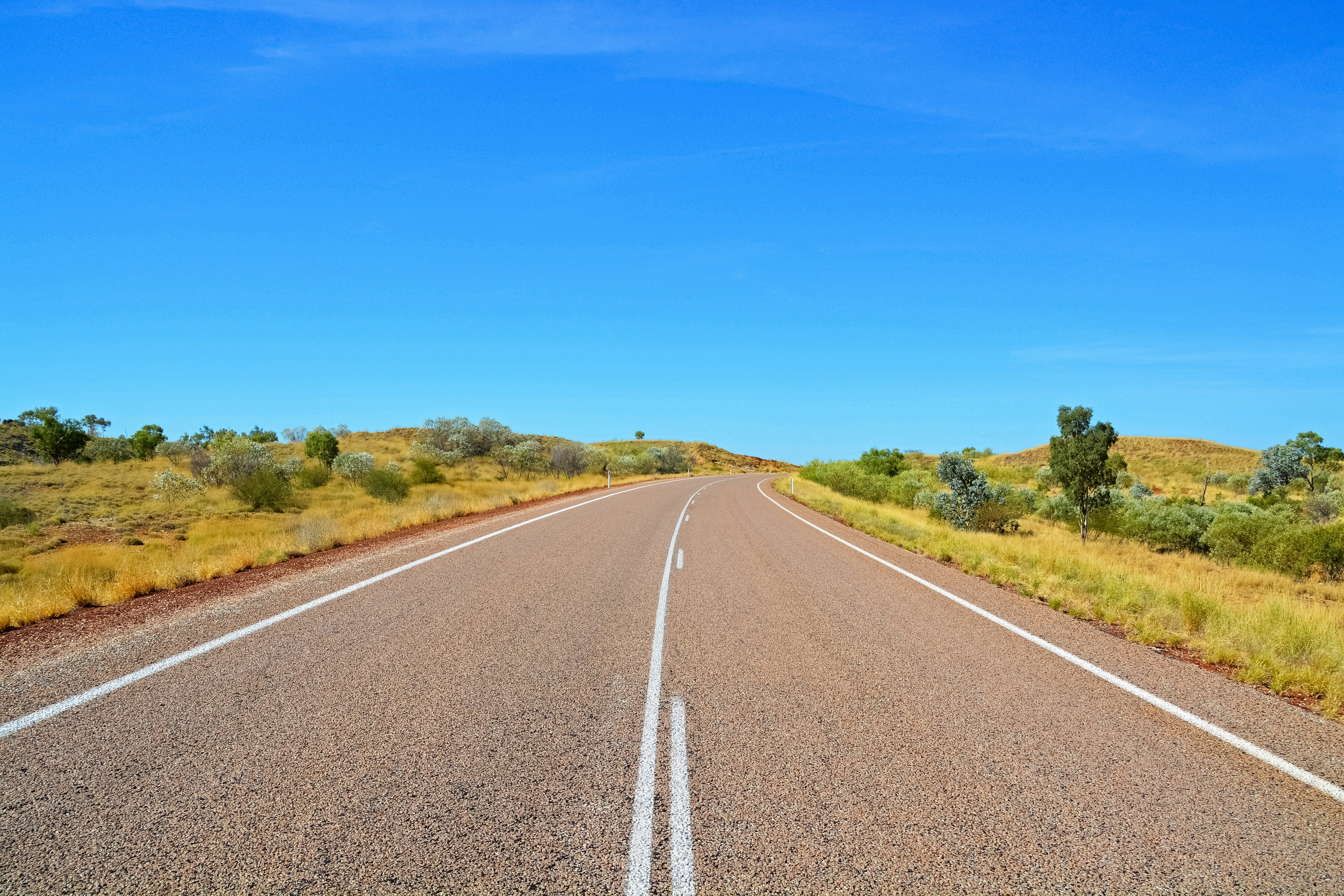 gray concrete road under blue sky during daytime